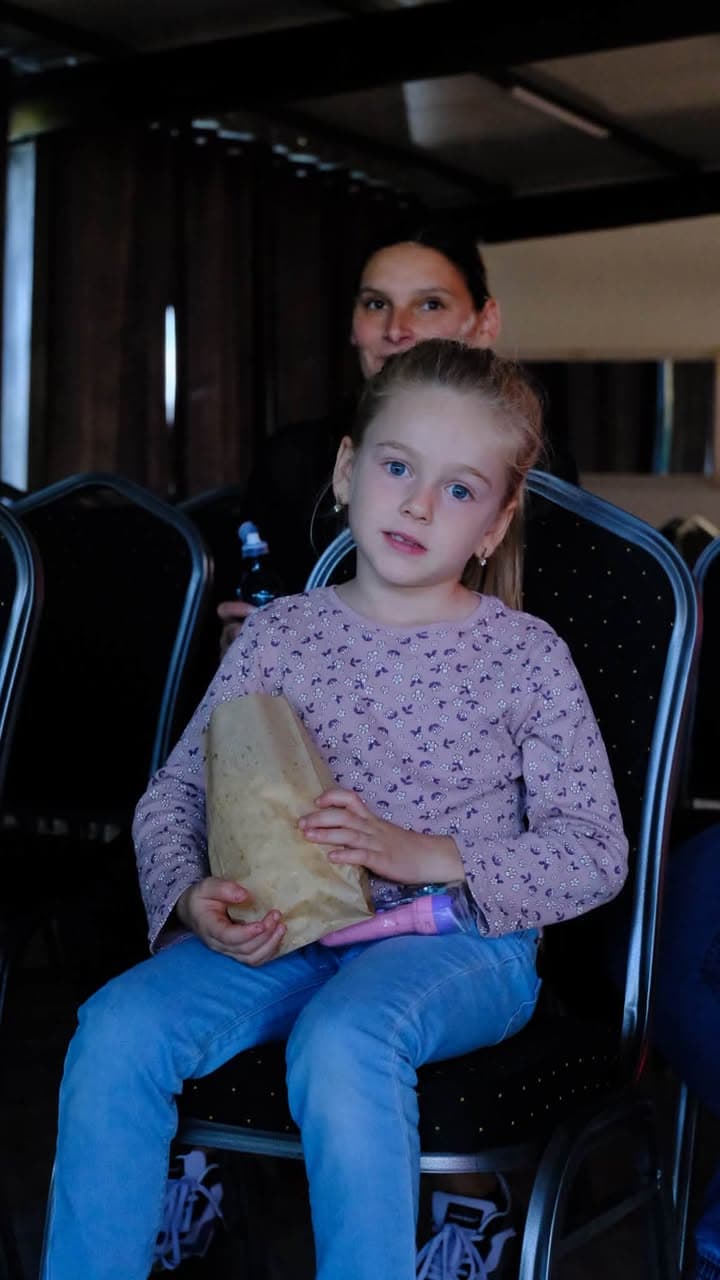 O fetiță cu o pungă de popcorn