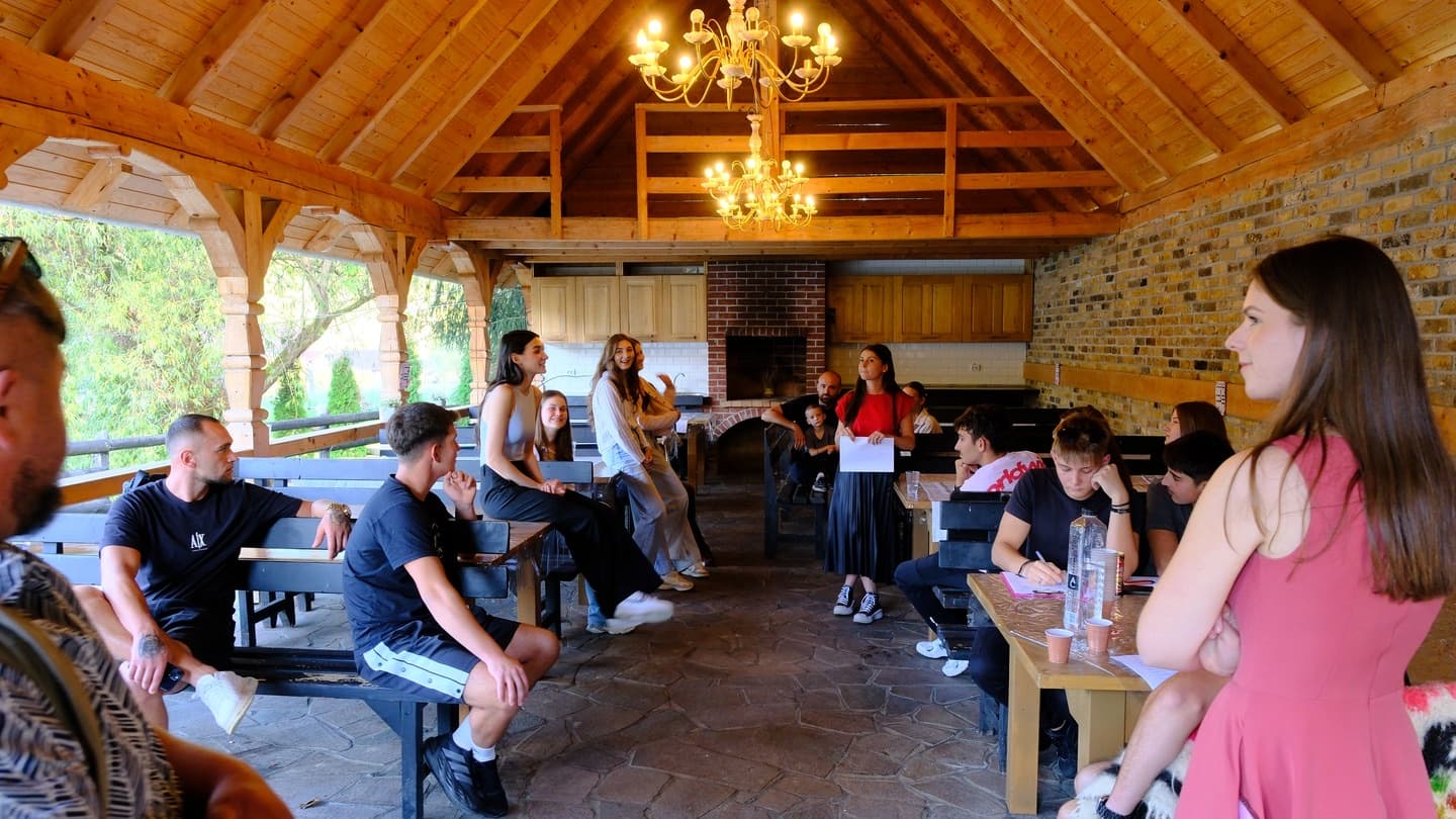 Tinerii ascultând, sub foișorul de lemn